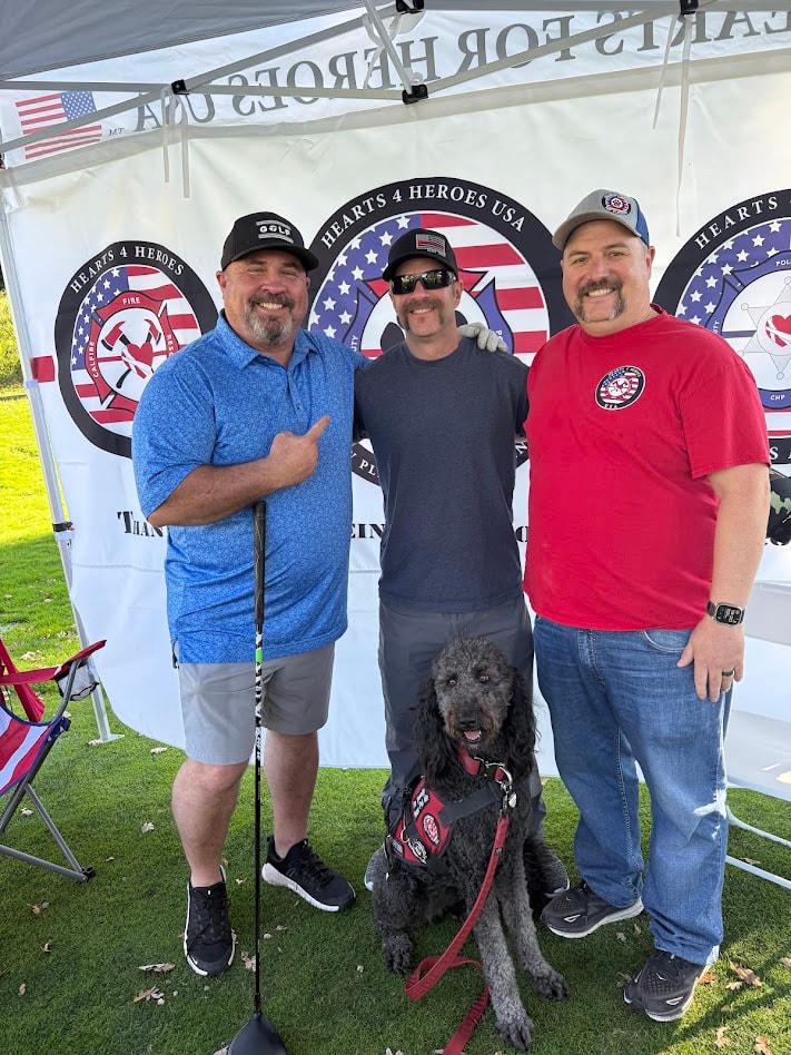Three men with service dog at Hearts 4 Heroes tent