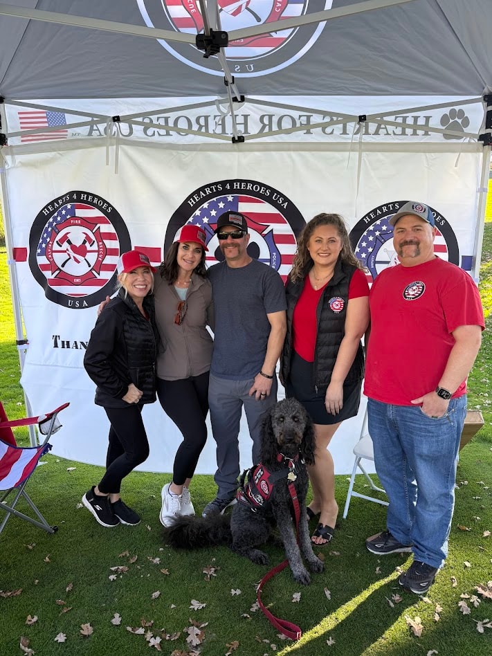Group with service dog at Hearts 4 Heroes tent