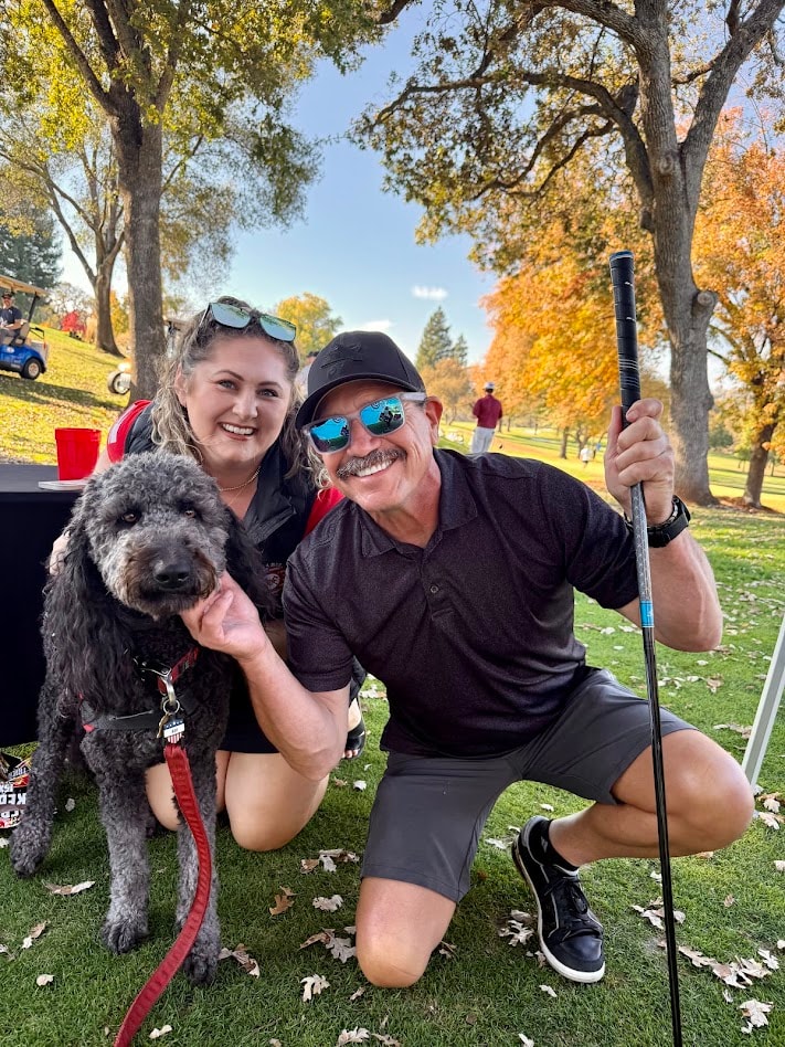 Couple with service dog at golf outing