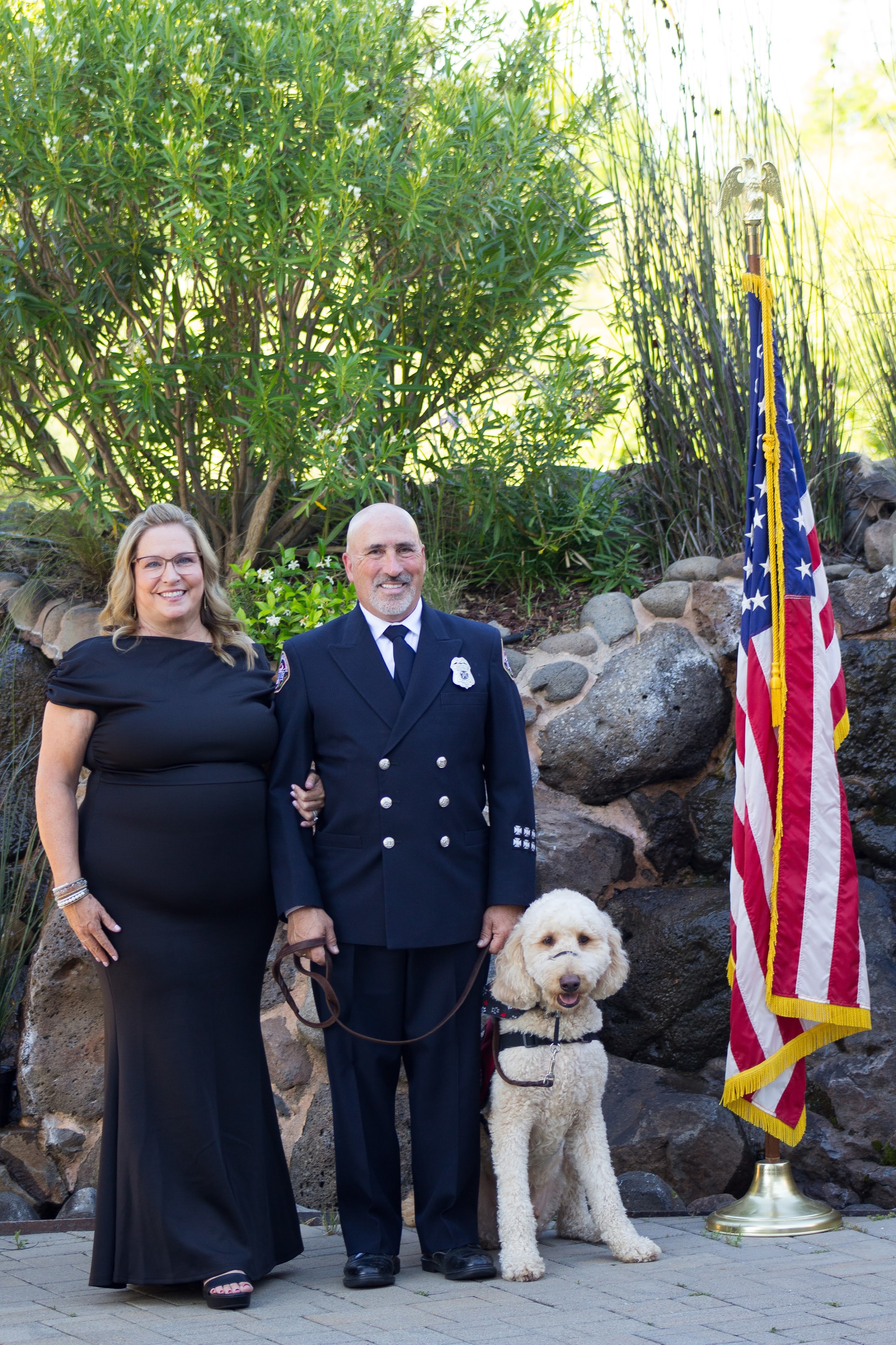 Dan Salois, his wife, and Blaze at the outdoor Hearts 4 Heroes gala with American flag