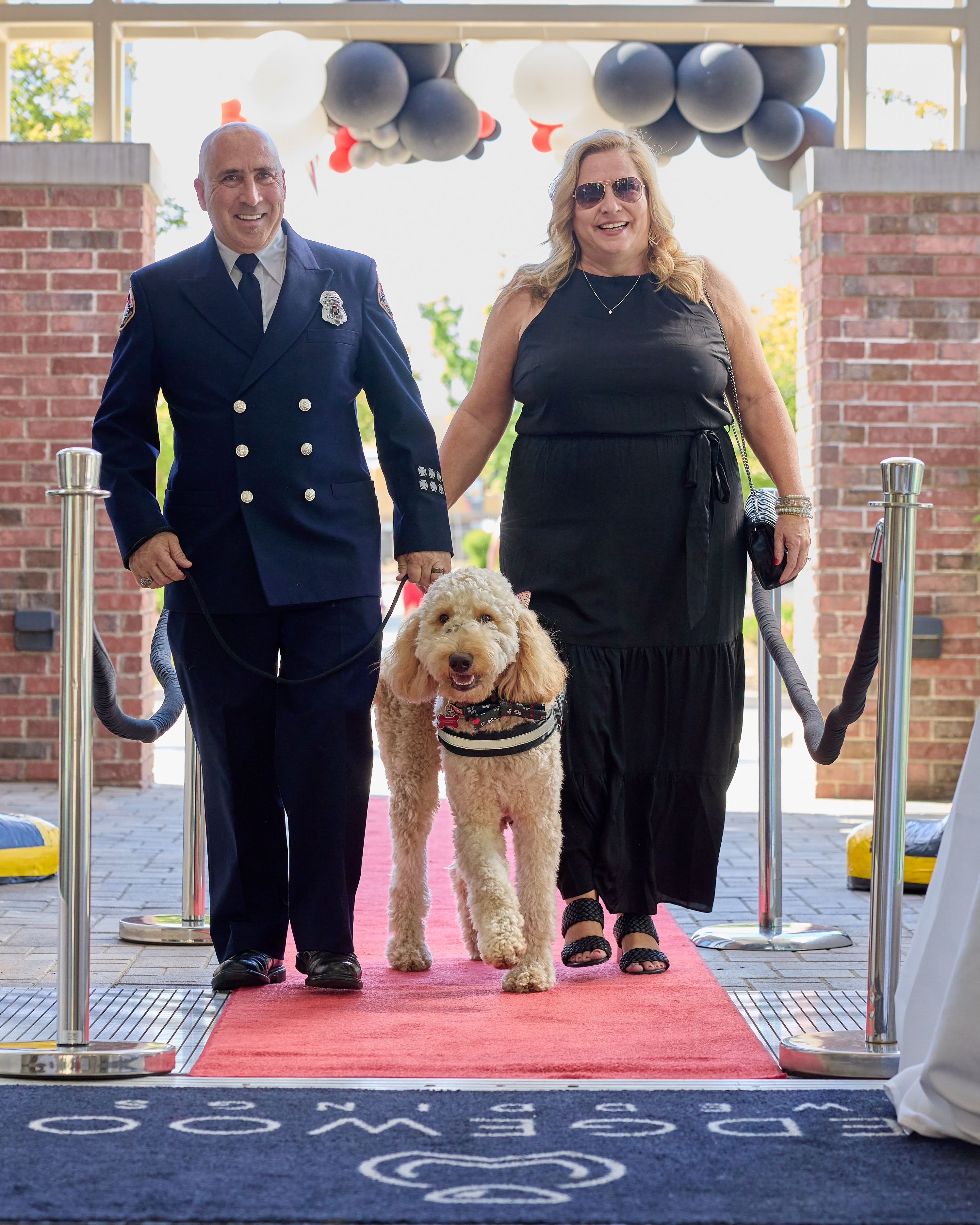 Dan Salois and his wife arriving with Blaze on the red carpet at the Hearts 4 Heroes gala