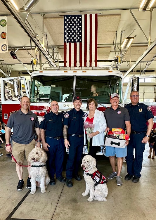 Roseville Fire Department crew with Captain Charlie and fellow Paw Platoon dogs at the station